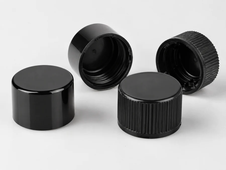 Glossy black cosmetic caps moulded with high color black masterbatch